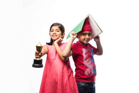 Indian  sikh / punjabi small girl and boy standing with a book and Victory Cupの写真素材
