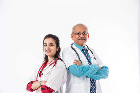 2 Indian Doctors - senior male and young female medical practitioner standing isolated with hands...
