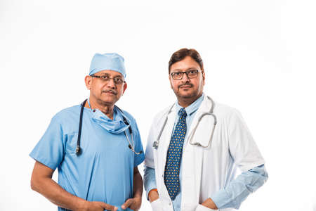 Indian/asian male surgeon and doctor/ medical practitioner standing together, isolated over white backgroundの写真素材