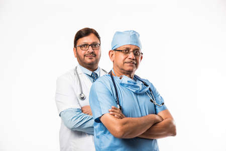 Indian/asian male surgeon and doctor/ medical practitioner standing together, isolated over white backgroundの写真素材