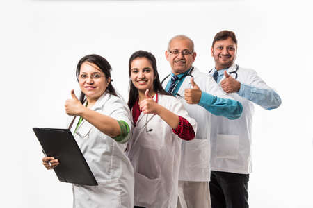 Indian/asian doctors group photo showing success/thumbs up sign. standing isolated over white background. selective focusの写真素材