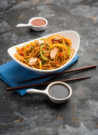 Chicken Hakka/Schezwan noodles served in a bowl with chopsticks. selective focusの写真素材