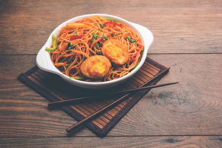 Egg Schezwan/hakka noodles, popular indochinese food served in a bowl with chopsticks. selective focusの写真素材