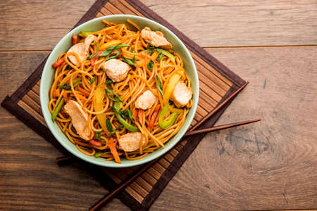 Chicken Hakka/Schezwan noodles served in a bowl with chopsticks. selective focusの写真素材