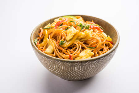 Egg Schezwan/hakka noodles, popular indochinese food served in a bowl with chopsticks. selective focusの写真素材