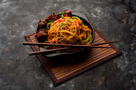 Manchurian Hakka / Schezwan noodles, popular indochinese food served in a bowl. selective focus