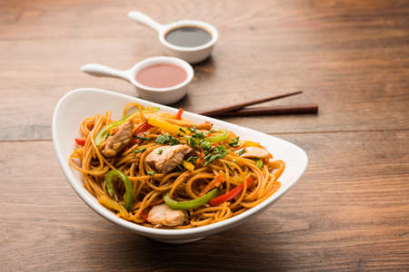 Chicken Hakka/Schezwan noodles served in a bowl with chopsticks. selective focusの写真素材