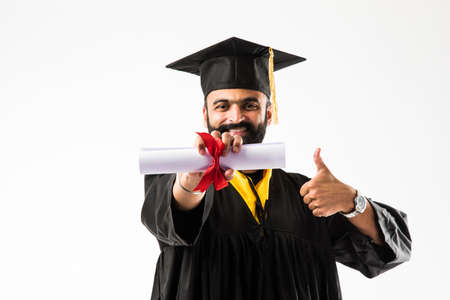 education, graduation and people concept - happy Indian Male graduate student in mortarboard and...