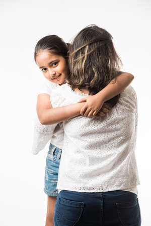 Indian mother daughter on white background hugging, kissing, riding, flying, pointing, presenting over white backgroundの写真素材