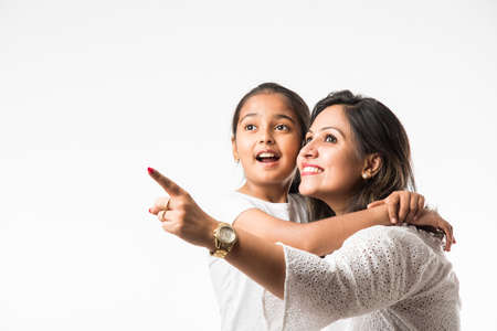 Indian mother daughter on white background hugging, kissing, riding, flying, pointing, presenting over white backgroundの写真素材