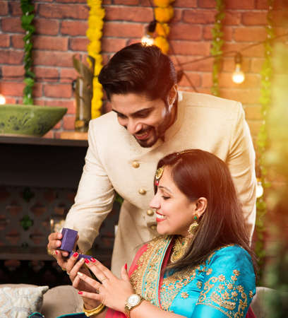 Indian man giving surprise gift to wife, jewellery on Diwali or Wedding anniversary, selective focusの写真素材