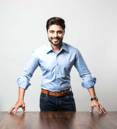 Indian businessman standing at tableの写真素材