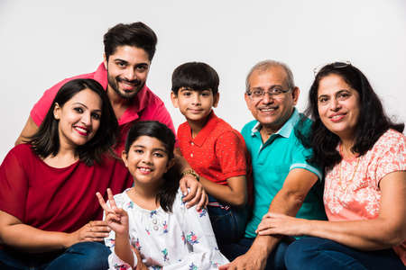 Indian Kids with parents / grandparents, sitting isolated over white background, studio shot