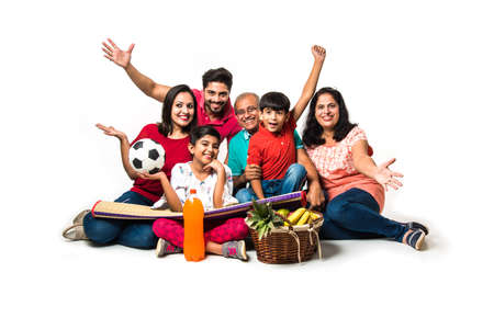 Indian Kids with parents / grandparents, sitting isolated over white background, studio shot
