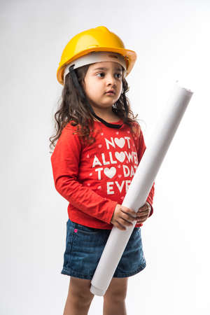 Small Indian girl engineer with yellow hard Hat and Drawing paper roll or plan, isolated over white backgroundの写真素材