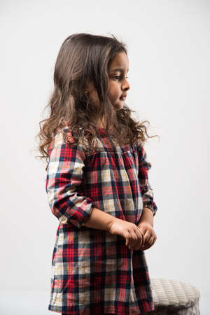 Indian small girl playing with soft toy, isolated over white backgroundの写真素材