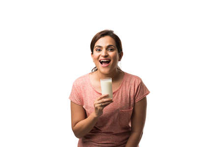 Portrait young Indian/asian woman drinking milk from the glass isolated over white backgroundの写真素材