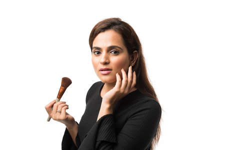 Indian young woman / Girl putting Makeup, standing isolated over white background