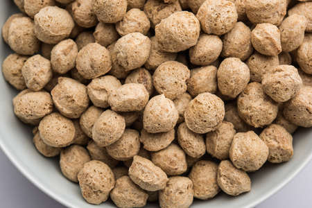 Raw Soya Chunks, Soy Meat for vegans isolated on colourful background in a bowl or in heap form