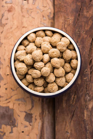 Raw Soya Chunks, Soy Meat for vegans isolated on colourful background in a bowl or in heap form