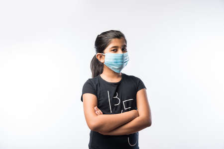 Indian Girl Child Wears Medical Face Mask as a safety measure against Pollution or Virus Spread,...