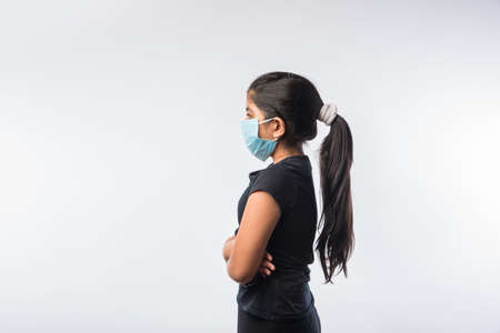Indian Girl Child Wears Medical Face Mask as a safety measure against Pollution or Virus Spread,...