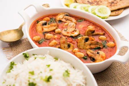 Mushroom sabzi in tomato curry with chickpea and spinach, Indian main course menu served with...