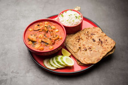 Mushroom sabzi in tomato curry with chickpea and spinach, Indian main course menu served with Paratha and cooked white riceの写真素材