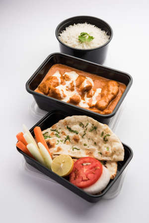 Indian butter chicken curry dish served in black plastic container for food delivery to homeの写真素材