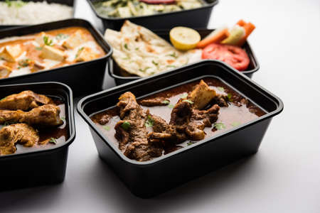 Online Food delivery concept Indian paneer butter masala and palak paneer, mutton & chicken curry with roti and rice in plastic containers, food like butter chicken, chickenの写真素材