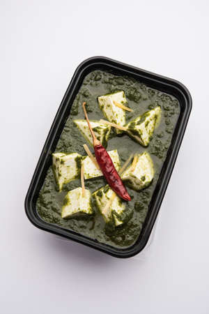 Palak Paneer with rice and chapati packed in a plastic container ready for home deliveryの写真素材