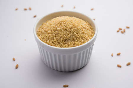Gehu Dalia or Daliya also known as Cracked or Broken Wheat, served in a bowl or spoon, healthy Indian foodの写真素材