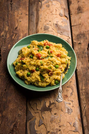 Vegetable Dalia or Daliya Khichadi or Broken Wheat Khichdi with tomato, green peas and chilli,...