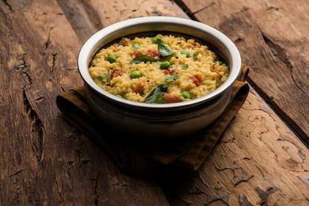 Vegetable Dalia or Daliya Khichadi or Broken Wheat Khichdi with tomato, green peas and chilli,...