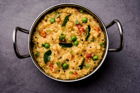 Vegetable Dalia or Daliya Khichadi or Broken Wheat Khichdi with tomato, green peas and chilli,...