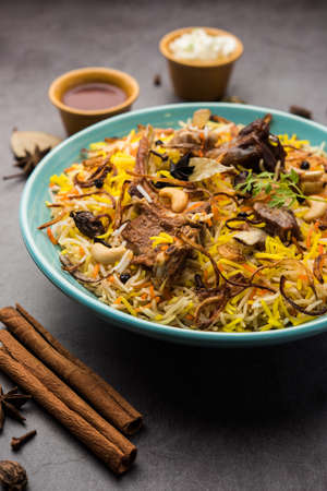 Restaurant style Gosht or Mutton Biryani served in a bowl with Raita and salanの写真素材