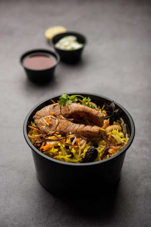 Restaurant style Fish Biryani or Pulao packed for home delivery in plastic box or container with Raita and salanの写真素材