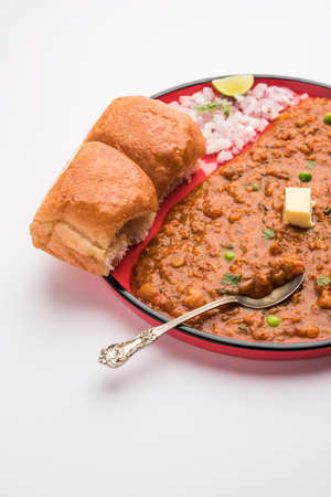 Mumbai Style Pav bhaji is a fast food dish from India, consists of a thick vegetable curry served with a soft bread roll, served in a plateの写真素材