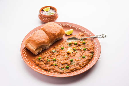 Mumbai Style Pav bhaji is a fast food dish from India, consists of a thick vegetable curry served with a soft bread roll, served in a plateの写真素材
