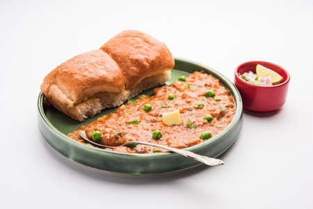 Mumbai Style Pav bhaji is a fast food dish from India, consists of a thick vegetable curry served with a soft bread roll, served in a plateの写真素材