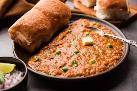 Mumbai Style Pav bhaji is a fast food dish from India, consists of a thick vegetable curry served with a soft bread roll, served in a plateの写真素材