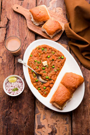 Mumbai Style Pav bhaji is a fast food dish from India, consists of a thick vegetable curry served with a soft bread roll, served in a plateの写真素材