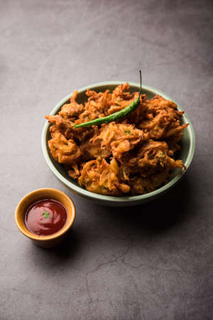 Fried onion pakora or Pyaj Pakoda also known as Crispy Kanda bhaji /Bhajji / bajji, favourite Indian Tea-Time snack during the rainy season. served with tomato ketchupの写真素材