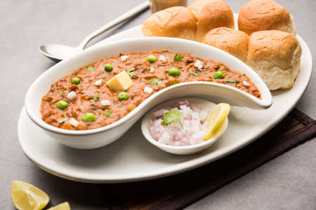 Mumbai Style Pav bhaji is a fast food dish from India, consists of a thick vegetable curry served with a soft bread roll, served in a plateの写真素材