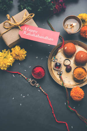 Raksha Bandhan / Rakshabandhan Rakhi with Haldi Kumkum rice, sweet Mithai, Gift Box, selective focusの写真素材