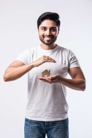 Indian Handsome man holding 3D House model made up of paper - real estate conceptの写真素材