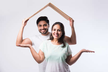 Indian young family couple and real estate concept - buying or rental, standing against white backgroundの写真素材