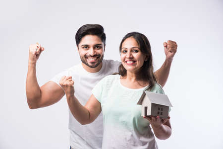 Indian young family couple and real estate concept - buying or rental, standing against white backgroundの写真素材