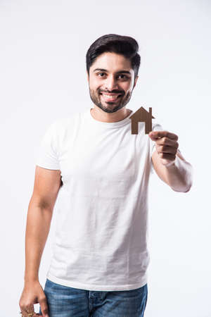 Indian Handsome man holding 3D House model made up of paper - real estate conceptの写真素材