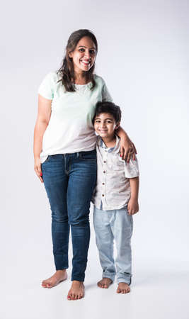 Portrait of Indian young mother and son against white background, looking at cameraの写真素材